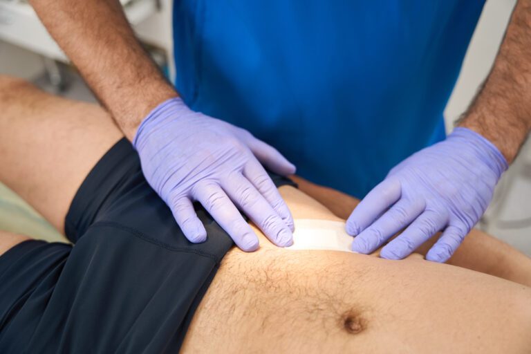 Surgeon phlebolist applying adhesive plaster on patient stomach after injections